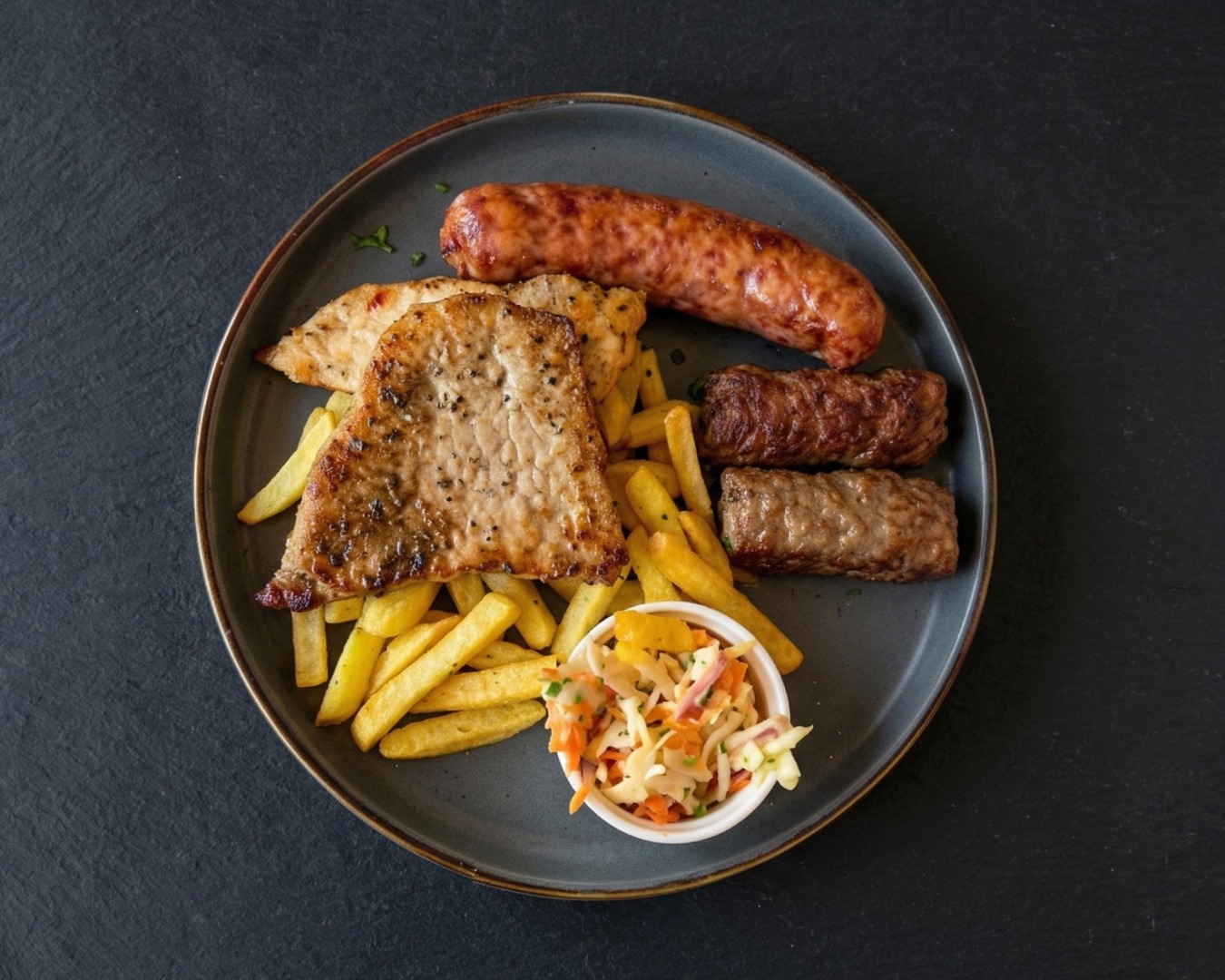 Platou grill mixt cu cârnați, mici, antricot de porc și cartofi prăjiți